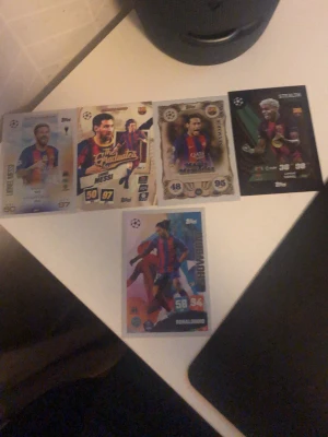 Samling fotbollskort FC Barcelona - Fem olika fotbollskort med spelare från FC Barcelona, bland annat Messi och Ronaldinho. Korten har färgstarka tryck, olika designer och detaljer som stats och klubbmärke. Perfekt för dig som gillar samlarkort och fotboll.