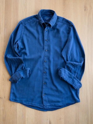Blå skjorta från Eton i bomull, size M - Snygg blå skjorta från Eton i mjuk bomull. Klassisk modell med knappar framtill och lång ärm. Perfekt för dig som gillar stilrena plagg med en avslappnad känsla. Skjortan har en tidlös krage och passar till många olika looks.
