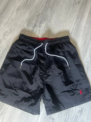 Svarta badbyxor från Polo Ralph Lauren - Tjena. Jag säljer mina Ralph Lauren bad byxor pga dem inte används någon mer för att jag har växt ifrån dem. Sitter riktigt fint. Dem är perfekt för den kommande bad säsongen om du vill stå ut från alla andra. Skriv pm för mer bilder. 😁