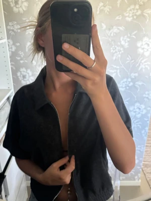 Mörkgrå kortärmad ziptröja - Säljer en mörkgrå kofta/zip tröja ifrån Zara som bara är använd 1 gång😁Passar jätte bra att ha ett linne/ T-shirt under. Säljer då den inte kommer till användning🌸