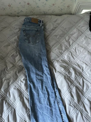 Blå raka jeans från Gina tricot - Säljer ett par klassiska blå bout cut jeans från gina tricot med snygga kontrastsömmar och broderad bakficka. Jeansen har låg midja och är gjorda i slitstark denim. Perfekta för en avslappnad och trendig look. 