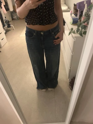 Blåa wide leg jeans med låg midja - Säljer ett par blåa wide leg jeans med låg midja och klassisk femficksmodell från Pull & Bear. Jeansen har en avslappnad passform och är tillverkade i denim. Perfekta för en chill,  trendig, och baggy look. Jag har kortat ner jeansen, passar till 155-163 cm. Jag är 156💕