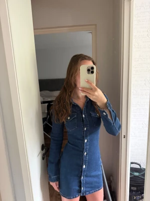 Jeansklänning - Zara - Säljer denna snygga jeansklänning med långa ärmar och knappar hela vägen framtill. Klänningen har två bröstfickor och markerad midja för en slim passform☺️