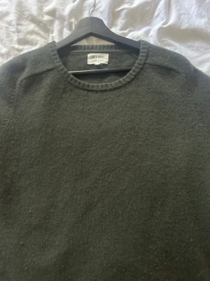 Mörkgrön kashmirtröja Soft Goat -  mörkgrön stickad tröja från Soft Goat i 100% kashmir. Tröjan har rund halsringning och ribbade muddar vid halsen. Perfekt för dig som vill ha en enkel men lyxig stickad tröja i garderoben.