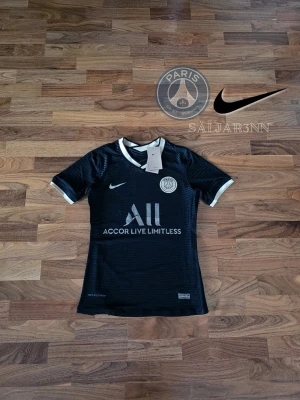 PSG Special Edition - PSG Special Edition Matchtröja – Sällsynt Unik Paris Saint-Germain special edition-tröja i svart/guld design med exklusiv detaljfinish. Lätt och ventilerande Nike Dri-FIT ADV material med premium känsla. Klassisk PSG badge på bröstet och subtila gulddetaljer som ger en lyxig och sällsynt look. Perfekt för samlare eller matchdagar. Helt ny med tags kvar. 📦 Snabb leverans – skickas samma dag (om ej hindr.) 📩 Kontakta vid frågor.