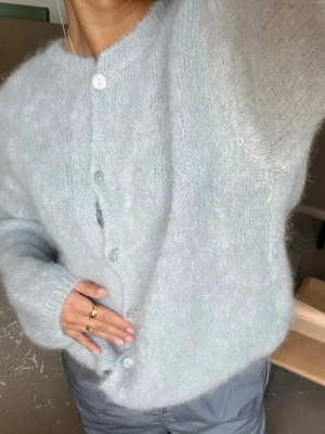Ljusgrå mohair kofta från Design by si - Supermjuk och fluffig ljusgrå kofta från design by si, perfekt till kyligare sommarkvällar eller nu till hösten. Den är endast använd två gånger av mig. Säljer då jag har samma i vit, men verkligen så mysig. Nypris är 760 kr.