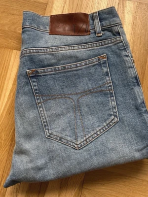 Blåa tiger sweden jeans - Säljer ett par klassiska blå jeans med slim passform. Jeansen har fem fickor och normal midja. Perfekta för en avslappnad stil och passar till det mesta. Materialet är denim och färgen är en mellanmörk blå nyans.