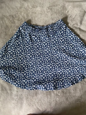Vit och mörkblå blommig kjol - Köpt på lager 157. Mörkblå bakgrund med vita blommor.