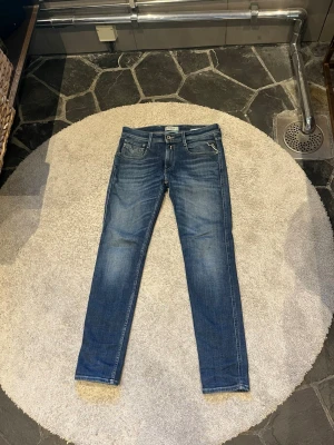 Replay anbass - Snygga blå skinny jeans från Replay med klassisk femficksdesign och läderpatch bak i midjan. Jeansen har en smal passform och är tillverkade i stretchigt denimtyg för extra komfort. Perfekta för en trendig och avslappnad look.
