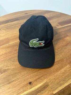 Lacoste Keps Svart Onesize - Säljer en Lacoste keps svart. Storlek: Onesize Köpt på Zalando.