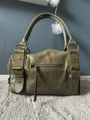 Olivgrön handväska  - Säljer en supersnygg olivgrön handväska från Pull & Bear. Perfekt vardagsväska – lagom stor och passar till allt! Använd endast två gånger, så den är i mycket fint skick ✨ Alla dragkedjor funkar som de ska. 💚 Färg: olivgrön 👜 Märke: Pull & Bear Hör gärna av dig vid frågor!
