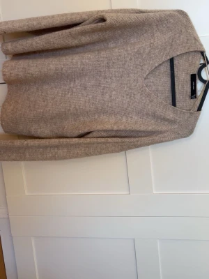 Beige stickad tröja Vero Moda - Säljer en beige stickad tröja från Vero Moda i storlek XS. Tröjan har v-ringning, långa ärmar och är gjord i ett mjukt, ribbstickat material. Perfekt för lager-på-lager och enkel att matcha med jeans eller kjol.