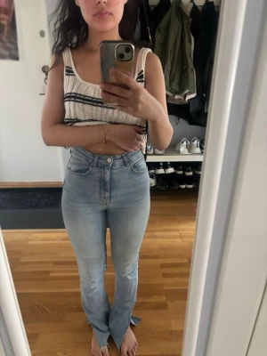 Ljusblå high waist bootcut jeans - Säljer ett par ljusblå jeans med high waist och bootcut-modell. Jeansen har klassisk femficksdesign och är tillverkade i stretchigt denimtyg för en bekväm passform. Perfekta för en avslappnad och trendig look.