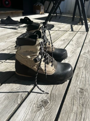  Lundhags kängor  - Snygga kängor från Lundhags i svart och beige med högt skaft och kraftig snörning. Ovandelen är i slitstarkt läder och textil, medan tån och hälen är förstärkta med gummi. Perfekta för uteliv och äventyr. Ny pris 3500