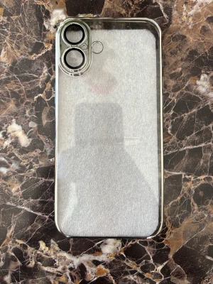 Transparent mobilskal iPhone 16 - Snyggt genomskinligt mobilskal med silvrig ram och förstärkt kameraskydd. Skalets material är plast som ger bra grepp och skydd utan att dölja mobilens design. För iPhone 16
