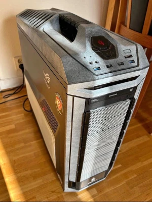 Stationär gamingdator - Säljer en kraftfull stationär dator med ett grått och svart ROG-chassi i metall och plast. Utrustad med flera USB-portar, Samsung optisk enhet, CX600M nätaggregat och kylfläktar. Perfekt för gaming och tunga program tack vare robust design och bra luftflöde. OBS HÄMTAS I ÄNGELHOLM HELST 