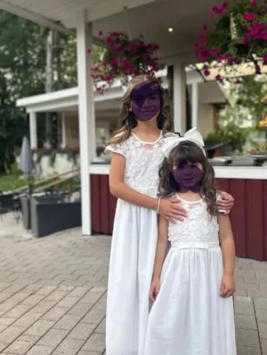 Vit långklänningar med spetsdetaljer storlek 110 och 140 - Superfin vit långklänning med spets och blommiga broderier upptill. Klänningen har korta ärmar i transparent tyg och ett markerat midjeband. Perfekt för speciella tillfällen och ger en elegant look.