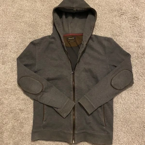 Massimo Dutti kofta  - Snygg grå hoodie från Massimo dutti med dragkedja och huva. Tröjan har unika armbågslappar och ribbade muddar vid ärmslut. Perfekt för en avslappnad stil. PRIS KAN DISKUTERAS!!