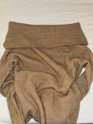 Beige stickad off shoulder tröja - Mysig beige stickad off shoulder tröja från H&M. Tröjan är ribbstickad i ett mjukt material. Perfekt för lager-på-lager och passar till många olika outfits.
