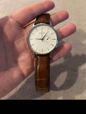Gant Park Hill 42mm Herrklocka - Säljer en snygg stilren herrklocka från amerikanska modejätten Gant i gott skick enligt bilder. Finns repor på glaset. Fungerar bra, originalarmband i äkta läder, datumvisare, vattentät osv. Behöver bara nytt batteri.  Nypris: 1900 SEK Begagnat pris: 1000 SEK Mitt pris: 489 SEK  Skickas alltid snabbt och spårbart (ofta samma dag) eller hämtas i Glumslöv.  Hör av dig vid frågor och se gärna mina andra annonser också!   Modellöversikt Märke Gant Ref.nr W10842 Rek. pris 1 910 kr Kategori Park Hill