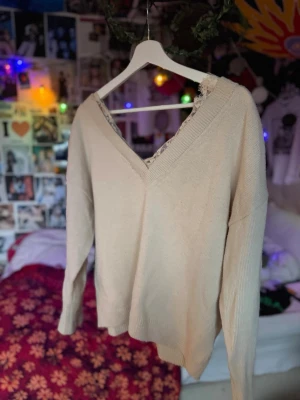 Beige stickad tröja!! - Beige stickad tröja med bred v-krage och spetsdetalj vid halsen. Den är i stolek M fast är ganska stretchig och baggy. ‼️fråga om mått/om du vill se på‼️