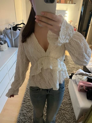 En vit blus med mönster - Säljer en vit blus med mönster i storlek M från Gina. Den har volanger och passar jättebra till jeans. Skriv om du undrar något💕