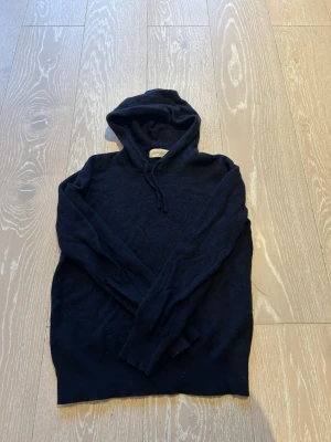 Mörkblå cashmere hoodie Sayless - Mysig mörkblå hoodie från Sayless i lyxigt cashmere-material. Klassisk modell med huva och dragsko, samt långa ärmar. Perfekt för dig som vill ha en stilren och bekväm hoodie med exklusiv känsla. Enkel att matcha till olika outfits. Bara att hojta till vid funderingar och liknande😊