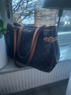 Louis Vuitton Monogram Batignolles Horizontal Tote Bag. - Säljer Louis Vuitton Monogram Batignolles Horizontal Tote Bag. Köpt den 31 december 2025 från ”A retro tale” vilket är ett företag som tar in begagnade vintage väskor och säljer vidare. Väskorna är noga inspekterade och kollade av experter för att kolla äktheten och dom säljer endast äkta väskor. Köpt för 7900kr.  Kvitto/orderbekräftelse finns även att kunna se. Säljer pga att det var för mycket pengar för mig att lägga på en väska just nu som jag inte riktigt insåg förens nu efter köpet…