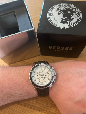 Versus Versace Aberdeen 45mm Herrklocka - Säljer en moderiktig herrklocka i dykarutförande från exklusiva Versace i nyskick. Inga repor i glaset. Enstaka tecken på användning enligt bilder. Alla funktioner fungerar bra, originalarmband i äkta luftat läder, dag och datumvisare, vattentät, osv. Behöver bara nytt batteri vilket baksidan öppnats för. Fås i original låda från Versace.  Nypris: 2000 SEK Begagnat pris: 1000 SEK Mitt pris: 689 SEK  Skickas alltid snabbt och spårbart (ofta samma dag). Hör av dig vid frågor/se andra annonser.