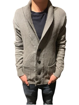 Grå  kofta med knappar - Snygg grå ribbstickad kofta med bred krage och fyra svarta knappar framtill. Koftan har två fickor och långa ärmar, perfekt för lager-på-lager. Materialet är mjukt och ger en avslappnad look.