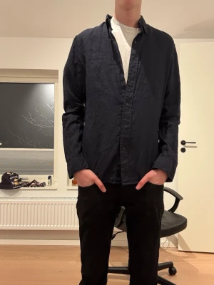 Mörkblå linneskjorta från Cubus - Säljer en stilren mörkblå skjorta från Cubus i 100% linne. Skjortan har klassisk krage, knappar framtill och lång ärm. Regular fit för en avslappnad men snygg look. Perfekt till både jeans och chinos. Kika gemensamma annonsen om du söker fler skjortor till våren eller sommaren! Hör av er vid eventuella frågor