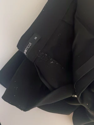 Svarta kostymbyxor från Gina tricot - Snygga svarta kostymbyxor från Gina i klassisk rak modell. Byxorna har knapp- och dragkedjestängning samt fickor fram. Perfekta till en stilren och clean look. Materialet känns mjukt och följsamt.