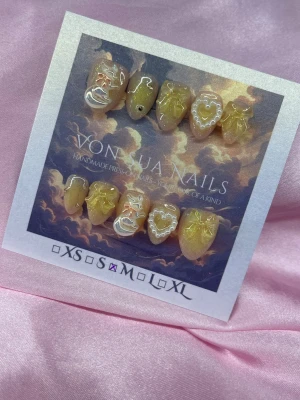 Gula press-on naglar med hjärtan - Unika handgjorda press-on naglar i gul och nude med detaljer, hjärtan och räv 🦊charms. I en kort almond form, i M: 16 mm, 12 mm, 12,5 mm, 11,5 mm, 10 mm. Perfekt för dig som vill ha något kreativt och trendigt på naglarna.