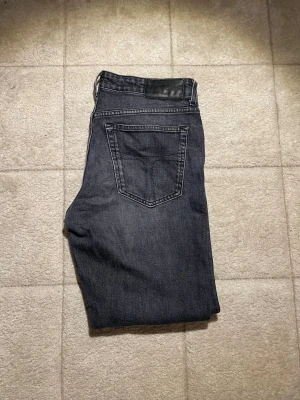 Mörkblå jeans från tiger of sweden 28/32 - Säljer ett par mörkblå jeans från tiger of sweden i modellen HAUNT. Klassisk femficksdesign med raka ben och snygga kontrastsömmar. Tillverkade i slitstarkt denimtyg, perfekta för en avslappnad och stilren look.