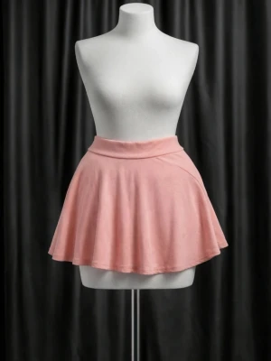 Ljusrosa kortkjol i bomull - Säljer en ljusrosa kortkjol med utsvängd form. Kjolen är tillverkad i mjuk bomull och har en enkel, clean design utan mönster eller detaljer. Perfekt för dig som gillar en feminin och avslappnad stil.