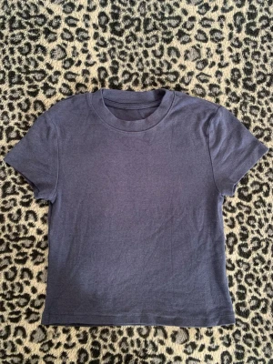 Mörkblå croppad t-shirt - En enkel och stilren mörkblå croppad t-shirt med rund hals och korta ärmar. Perfekt basplagg som passar till allt. Tillverkad i mjuk bomull för skön känsla hela dagen.