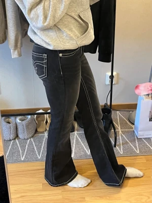 Low Rise Bootcut Jeans från Gina YOUNG - Mörkgråa lågmidjade bootcut Jeans från Gina Tricot YOUNG 💕 Storlek 164 vilket är typ samma som XS/34 💕De har även justerbara band 💕Säljes pga kommer inte till användning 