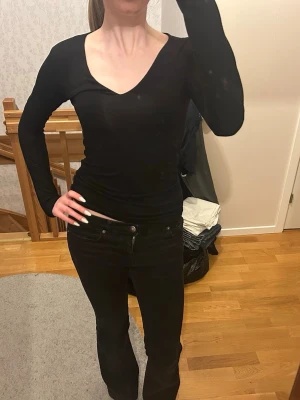 Svart långärmad topp med v-ringning - En stilren svart långärmad topp från Samsøe Samsøe med djup v-ringning. Tunn och sitter jättebra!
