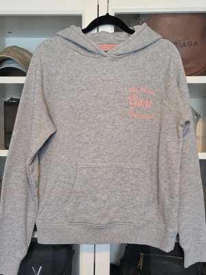 Grå sweatshirt från Gant - Säljer en grå sweatshirt från Gant med rosa broderad text 'New Haven Gant Connecticut'. Tröjan är i fint skick. Strl S 