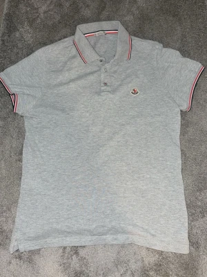 Grå pikétröja från Moncler - Säljer min Moncler piké i storlek S. Använd ungefär 15 gånger så man kan säga att den är i nyskick, inget fel på den alls. Säljer den eftersom den tyvärr inte passar mig längre , perfekt inför sommaren som nu är påväg! Fler funderingar? Skicka iväg ett meddelande tvivla inte!
