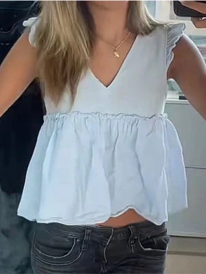 Ljusblå volangblus - Supersöt ljusblå blus från Zara med volang💗💗Blusen har korta volangärmar och snörning i ryggen för extra detalj. Perfekt till jeans eller kjol för en fräsch look. Pris kan diskuteras💕