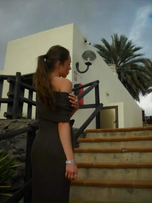 Brun ribbad offshoulder långklänning - Snygg brun långklänning med ribbad struktur och offshoulder-design. Klänningen har en kroppsnära passform och är off shoulder. Jag har sytt extra stygn vilket uppvisas på sista bilderna då ringningen gick långt ner, går enkelt att sprätta upp. xs men passar större. 