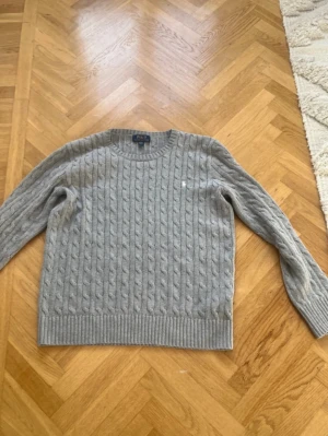 Grå kabelstickad tröja Polo Ralph Lauren - Hej säljer en grå stickat polo Ralph laurent tröja.Tröjan är I storlek S I väldigt bra skick.Ny pris 2366kr mitt pris 520kr