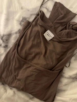 Brun linnetopp från Ginatricot - Säljer en brun linnetopp från Ginatricot, kollektionen Elevated Basics. Toppen är ärmlös med smala axelband och har en enkel, stilren design. 
