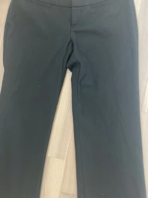 Svarta kostymbyxor med rak passform - Säljer ett par klassiska svarta kostymbyxor med rak passform och diskreta fickor framtill. Byxorna har en stilren look och passar perfekt till en snygg outfit. Riktigt mjuka och bekväma och man kan ha de både till vardagen och när man ska vara lite extra fin. Helt oanvända, har ingen prislapp däremot. Ordinarie pris: 279 kr. Meddela mig om du har några frågor eller funderingar! Pris kan diskuteras