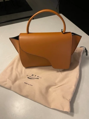 HELT NY! ATP Atelier Arezzo väska - Helt ny snygg handväska i slätt brunt läder från ATP Atelier. Lappar är kvar. Modellen är Arezzo och färgen heter brandy. Säljes pga dubbelköp av present som blivit liggande så att returrätt har gått ut. Nypris 5200kr.