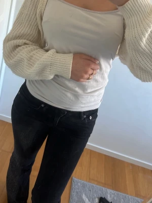 Vit ribbad linnetopp - Snygg vit linnetopp med smala axelband och ribbade detaljer. Toppen är ärmlös och har en enkel, stilren design som passar perfekt till jeans eller kjol. Materialet känns mjukt och bekvämt mot huden.