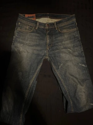 Jeans från Acne Studios - Säljer ett par klassiska blå jeans från Acne Studios med snygga vita slitningar. Jeansen är storlek🌟