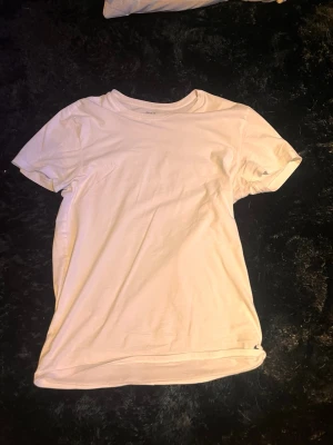 Vit t-shirt från Ralph Lauren - Klassisk vit t-shirt från Ralph Lauren med den ikoniska loggan broderad i svart nere vid fållen. T-shirten har rund halsringning och korta ärmar. Tillverkad i mjuk bomull för en skön och enkel stil.