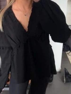 Svart volangblus NA-KD - Säljer denna supersöta svarta blus med volang modell ifrån NA-KD. Modellen heter ”Långärmad strukturerad blus med volang” och finns på deras hemsida för 399kr. Den är stilren och basic och stylas lätt till vardag som basplagg eller finare tillfällen. Storlek xs/34 och passar även 36. Den har v ringning med volang och en kortare och lös ”flowy” passform. Pris kan diskuteras vid snabb affär. Hör av er vid frågor! 💕